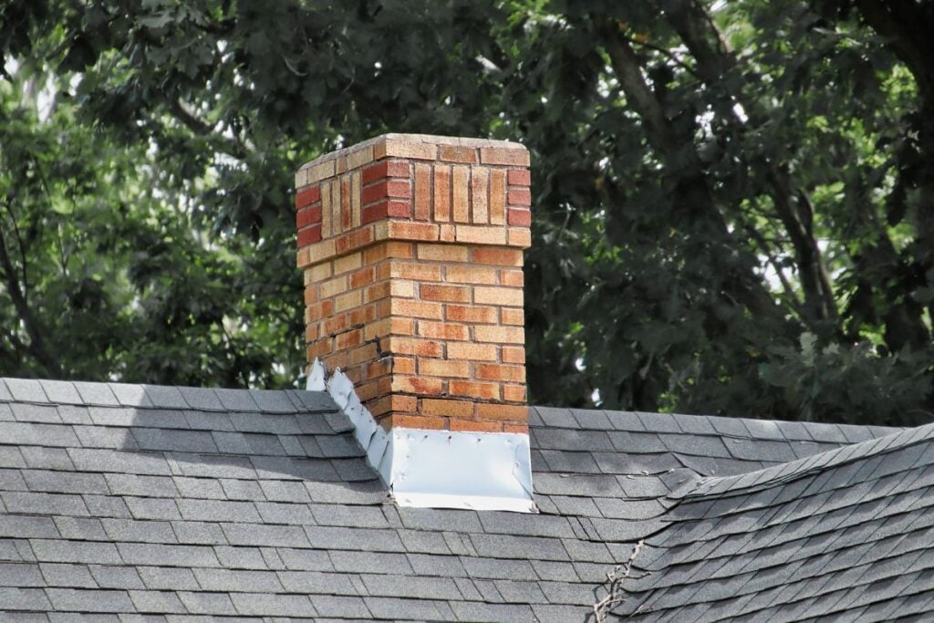 roof flashing repair grey shingles roof and brick wall