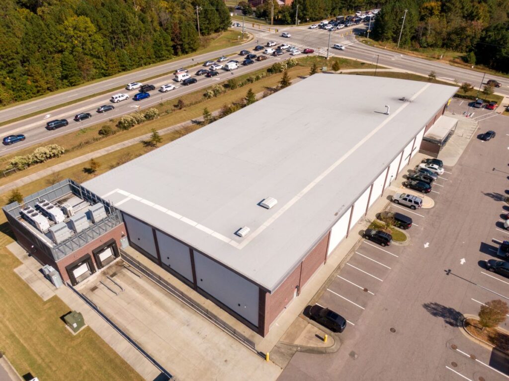 low slope roof grey metallic sheet commercial building with parking lot
