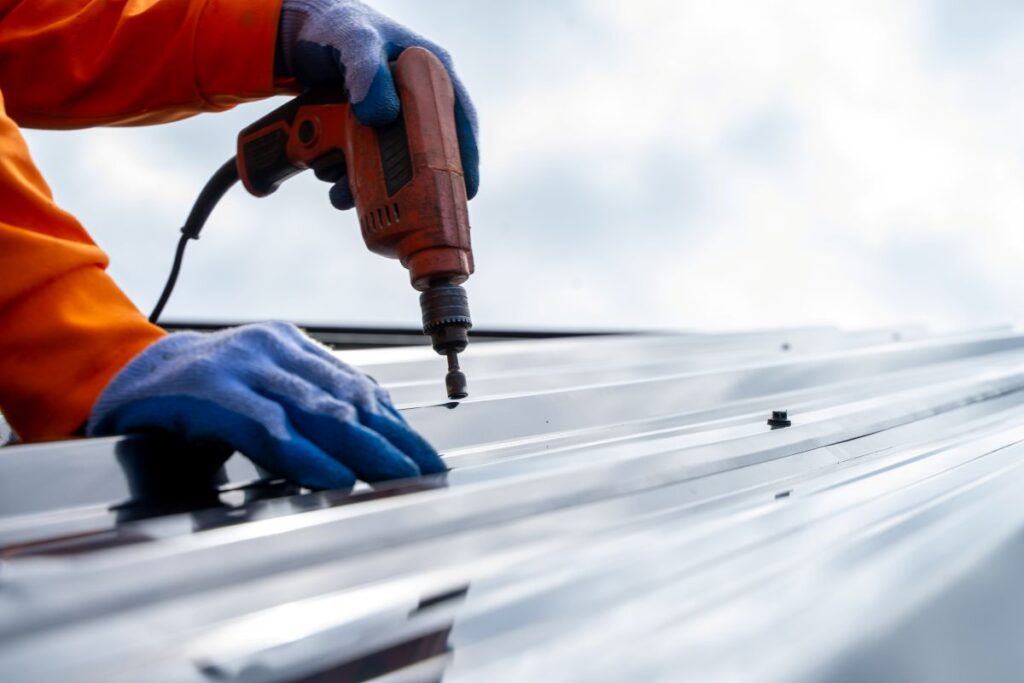 low slope roof grey metallic roof worker using gun